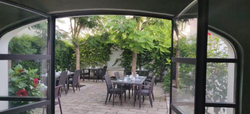 a patio with a table and chairs and trees at Palazzo Muro Leccese Relais de Charme & Wellness in Muro Leccese
