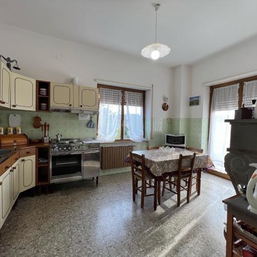 a kitchen with a table and chairs in a room at LE RADICI in Civitella dʼAgliano