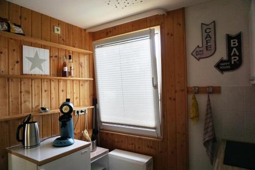 a kitchen with a window in a wooden wall at Bungalow Ulf in Lauchhammer