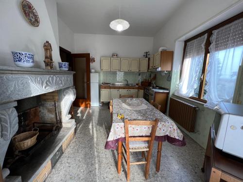 a kitchen with a table and a fireplace at LE RADICI in Civitella dʼAgliano