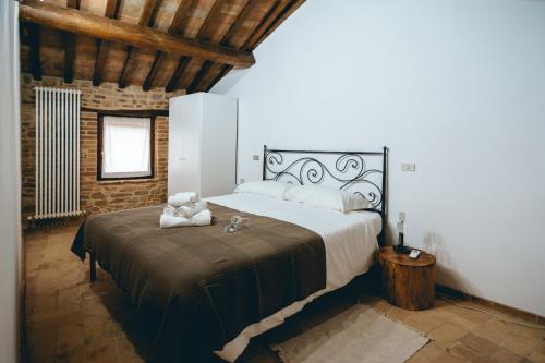 a bedroom with a large bed and a brick wall at Casa - Il Gioiello - con Jacuzzi e Sauna in Amandola