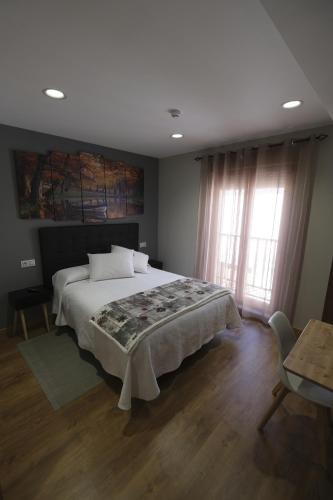 a bedroom with a large bed and a window at Hostal Restaurante Goya in Piedrahita