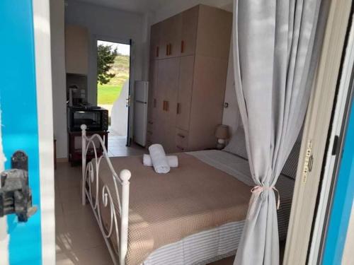 two pictures of a bedroom with a bed with curtains at Glyfada Suite in Kastraki Naxou