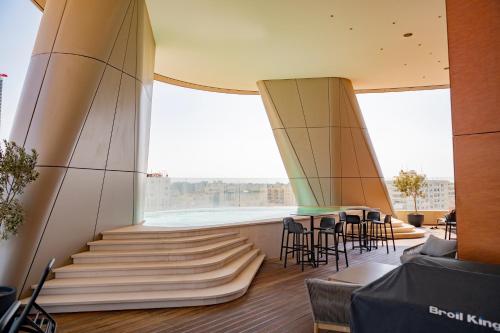 a room with stairs and chairs and large windows at 360 Nicosia - Luxury Apartment Panoramic View in Nicosia