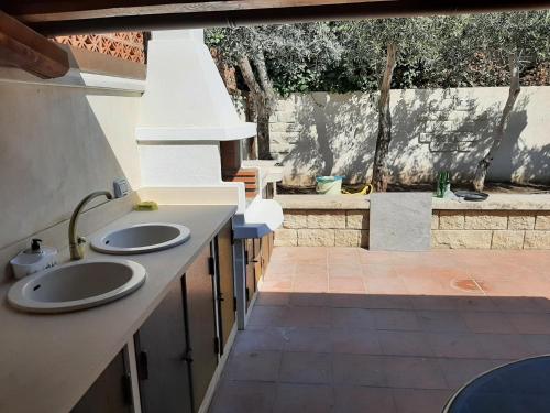 a kitchen with two sinks and a patio at Casa Romano - Marina di Modica in Marina di Modica