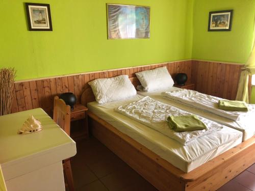 uma cama num quarto com uma parede verde em Villa Kunterbunt Ostsee em Schashagen
