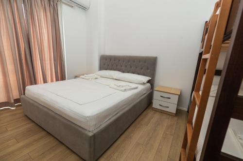 a small bedroom with a bed and a night stand at Ventus Hotel in Ksamil