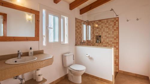 een badkamer met een toilet, een wastafel en een spiegel bij Agroturismo Son Rosas in Ciutadella