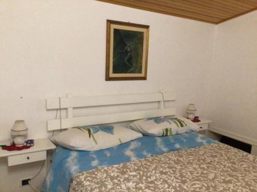 a bedroom with a bed and a picture on the wall at Casa Romano - Marina di Modica in Marina di Modica