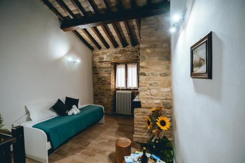 a living room with a bed and a brick wall at Casa - Il Gioiello - con Jacuzzi e Sauna in Amandola