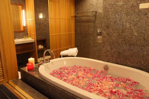 a bathroom with a tub filled with lots of sprinkles at Spring Spa Hotel in Wulai