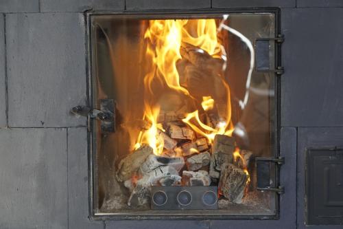 a fire is burning in a brick oven at Modiste in Kuldīga