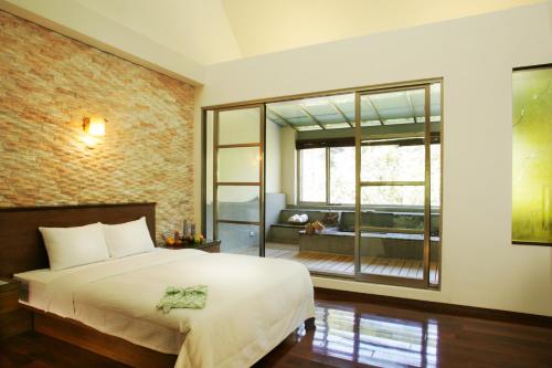a bedroom with a bed and a large window at Spring Spa Hotel in Wulai