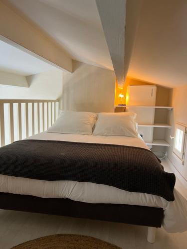 - une chambre avec un grand lit et une couette noire dans l'établissement Appartement proche village naturiste, terrasse et parking, au Cap d'Agde