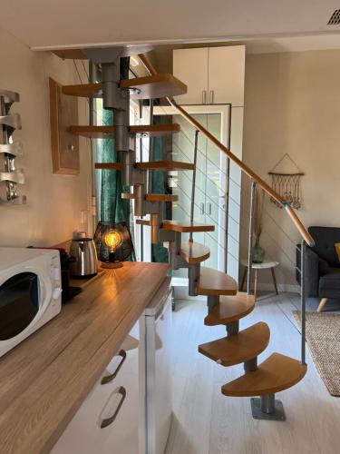 - un escalier en colimaçon dans un salon avec un four micro-ondes dans l'établissement Appartement proche village naturiste, terrasse et parking, au Cap d'Agde