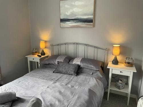 a bedroom with a bed with two night stands and two lamps at The Beach House, Suffolk Coast in Lowestoft