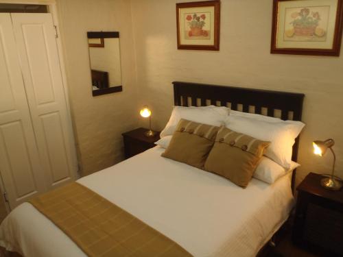 1 dormitorio con 1 cama con sábanas y almohadas blancas en Berg Treat, en Champagne Valley