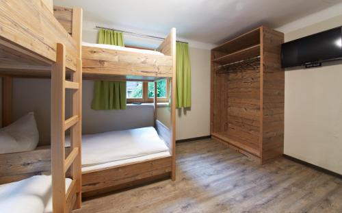 two bunk beds in a room with wooden walls at Holiday Lodge Central in Saalbach-Hinterglemm