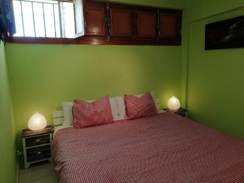 ein Schlafzimmer mit einem Bett mit roter Bettwäsche und zwei Lampen in der Unterkunft El Sol de Las Negras con vistas al mar in Las Negras
