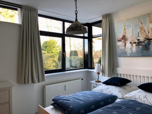 a bedroom with two beds and large windows at Ferienwohnung Ostsee Timmendorferstrand in Timmendorfer Strand