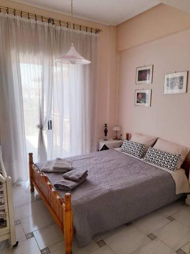 a bedroom with a large bed and a large window at Petalidi Square in Petalidhion