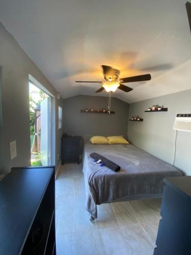 Un dormitorio con una cama y un ventilador de techo. en Cozy House, en Fort Lauderdale