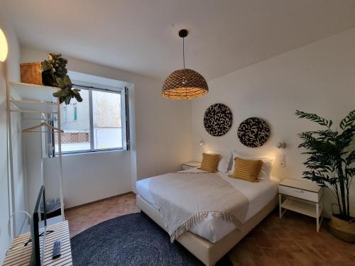 a bedroom with a bed and a potted plant at Casa Algarbe in Faro