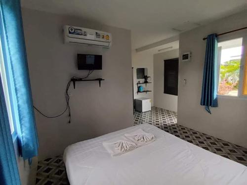 - une chambre avec un lit blanc et une fenêtre dans l'établissement บ้านสวนปลายนา Ban Suan Plai Na, à Ban Kaeng Tat Sai