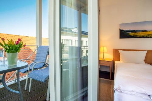 ビンツにあるNixe - Villa Helene mit Meerblick in Top Lageのベッドとテーブルのあるバルコニー付きの寝室