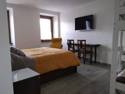 um quarto com uma cama, uma mesa e uma televisão em Monte Zucco Relax em San Pellegrino Terme