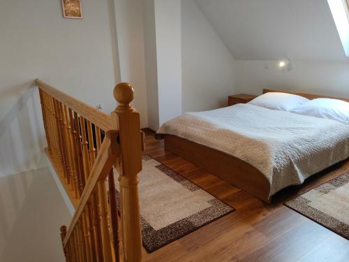 una camera con un letto e una scala in legno di Apartamenty Kołczewo a Kołczewo