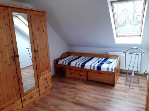 a bedroom with a bed and a cabinet and a window at Ferienwohnung Günther am Park in Ditfurt