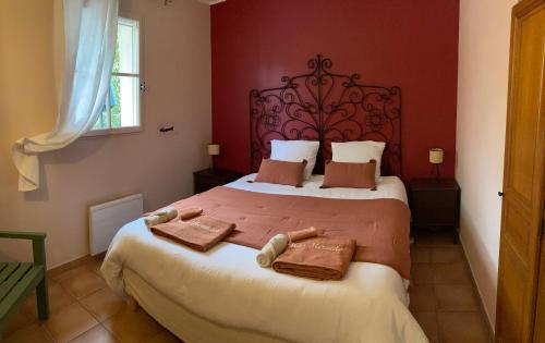 a bedroom with a large bed with two towels on it at Le Mas Mérindol Gîte Cerise in Loriol-du-Comtat