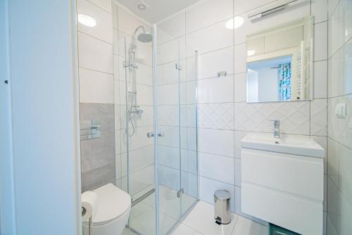 a bathroom with a shower and a toilet and a sink at Pokoje gościnne u Eli in Mrzeżyno