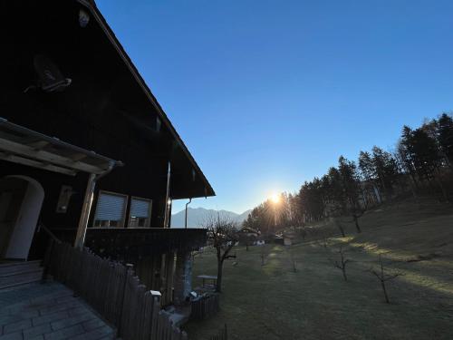 a house with the sun setting in the background at Beim Mühltaler in Schleching