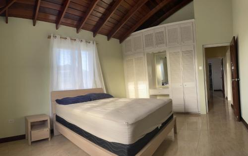 a bedroom with a large bed and a window at ‘JASPER’ Private Room with shared bathroom in Saint Philip
