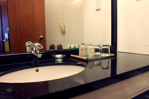 a bathroom with a sink and a mirror at Imperial Hotel Miri in Miri
