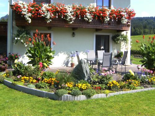 a flower garden in front of a house with flowers at Ferienwohnungen Kolbitsch in Greifenburg