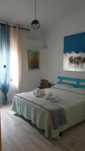 a bedroom with a bed and a painting on the wall at B&B Cala Luna in Cala Gonone