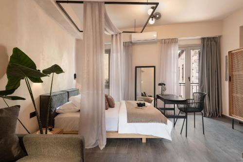 a bedroom with a bed and a table and chairs at Anaem Eclectic Rooms in Chania Town