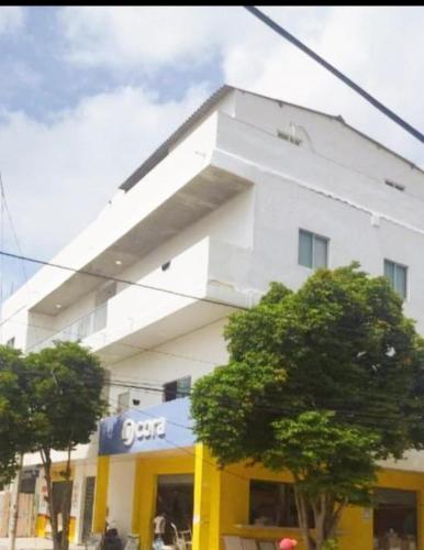 a white building with trees in front of it at Amiri in Puerto Colombia