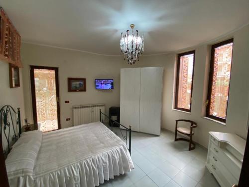 een slaapkamer met een bed en een kroonluchter bij Casa Nonna Bianca- appartamento pratico a pochi minuti da Napoli in Casalnuovo di Napoli