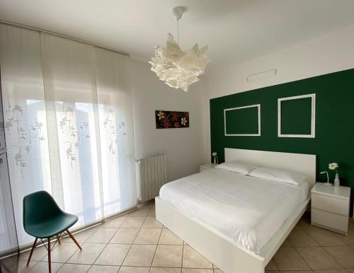 a bedroom with a white bed and a green wall at Appartamento ZenaUp in Saronno