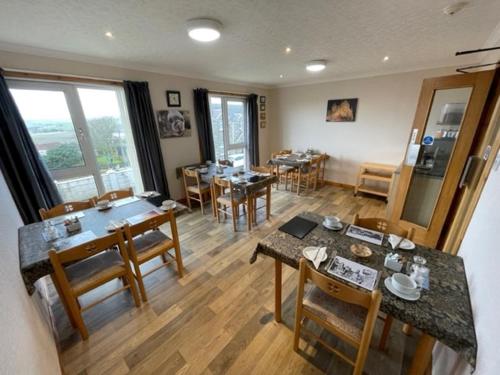 a dining room with tables and chairs in a room at Royal Oak Guesthouse in Orkney