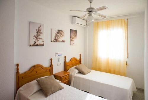 - une chambre avec 2 lits et un ventilateur de plafond dans l'établissement Vera Playa Fuentemar, à Vera