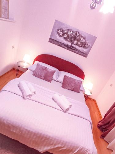 a bedroom with a large white bed with two pillows at Josipa & Jelena Apartment in Senj
