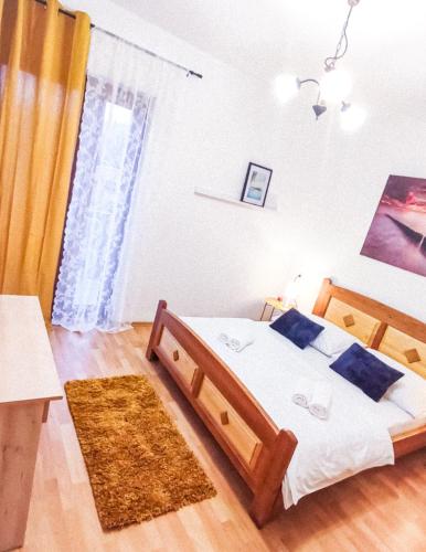 a bedroom with a large wooden bed with a rug at Josipa & Jelena Apartment in Senj