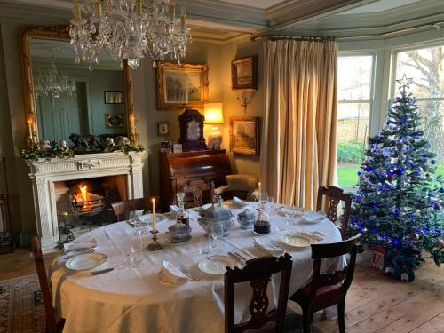 uma sala de jantar com uma mesa com uma árvore de Natal em Kilmorie House em Elgin