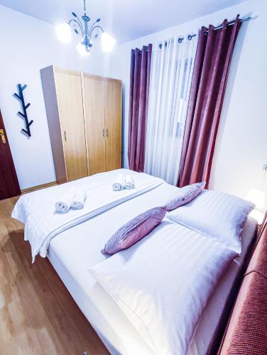 a bedroom with a bed with white sheets and pillows at Josipa & Jelena Apartment in Senj