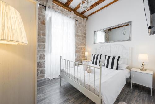 Un dormitorio con una cama blanca y una escalera en Premium Apartment, en Dubrovnik